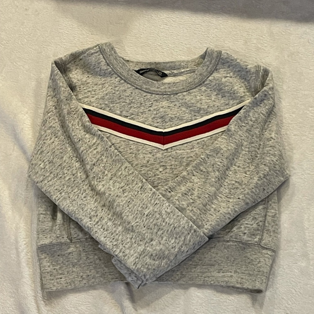 Gray long sleeve sweater with navy blue white and red triangle stripe
